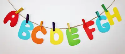 Bunte Buchstaben an Wäscheleine bilden das Wort "ABCDEFGH"